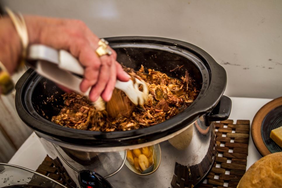 Persoană care folosește un slow cooker - Ce este și cum se folosește corect un slow cooker
