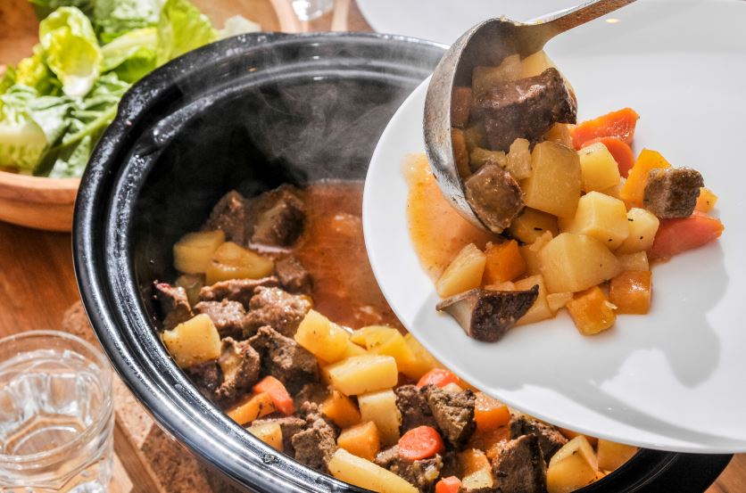 Mâncare scoasă pe farfurie dintr-un slow cooker exemplificând Ce mâncare poți găti la un slow cooker